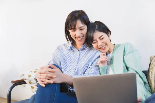 Two women looking at a computer (women, couple, same surname, friend, sister)