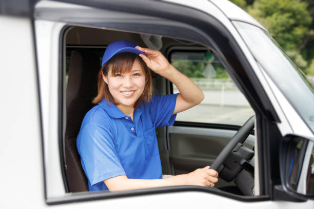 Female driver delivers packages with a smile. The image of a logistics, delivery, and moving company. stock photo