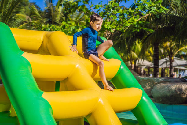 istock Cute boy runs an inflatable obstacle course in the pool 1419202173