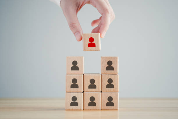 istock Human resources management and recruitment business hiring concept, corporate hierarchy, recruiter complete team by one leader person, professional staff research, hand hold red people icon on cube. 1419206631