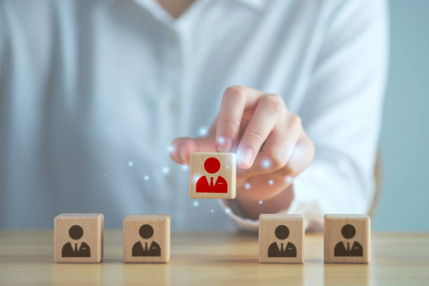 Business hiring and recruitment selection. Career opportunity. Human Resource Management. finding human. Hand choosing red business man icon on wooden block. Choice of employee leader from the crowd. contratación de empresas y selección de reclutamiento. oportunidad de carrera. gestión de recursos humanos. encontrar humano. elegir a mano el icono rojo del hombre de negocios en un bloque de madera. elección del líder de los empleados entre la multi
