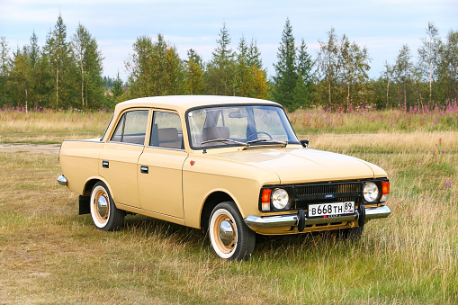 Novyy Urengoy, Russia - August 7, 2022: Classic Soviet car Izh-Moskvich-412 in a grass field.