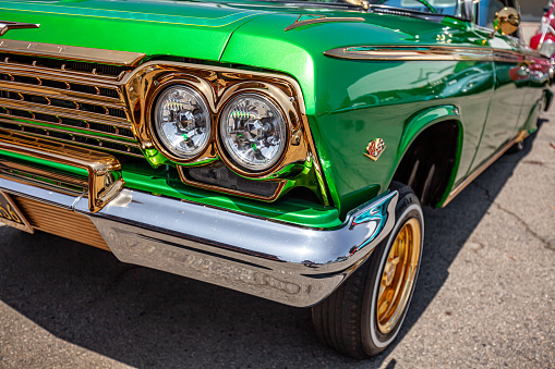 Los Angeles, CA, USA – August 21, 2022: Front Driver Quarter Shot of Green Candy Paint With Gold Accents Third Generation Chevy Impala at a Southern California Car Show In The Summer