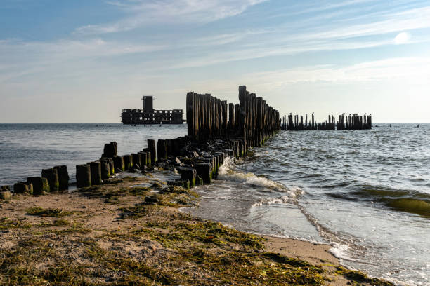 istock Old ruined wooden pier and a sandy beach 1419228561