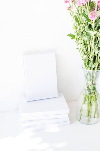 istock White book mockup with chrysanthemum flowers in a vase on a white table 1419228927