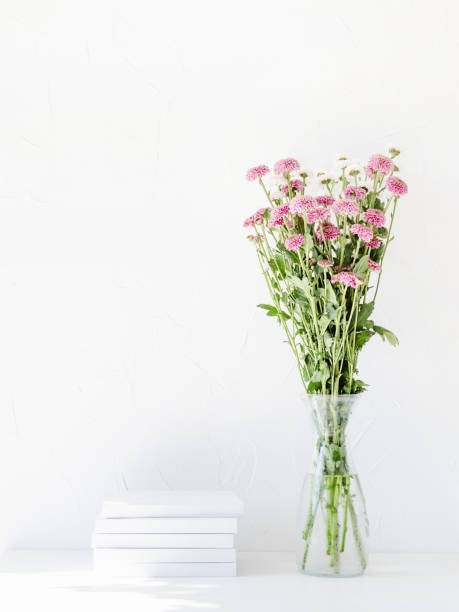 istock White book mockup with chrysanthemum flowers in a vase on a white table 1419228980