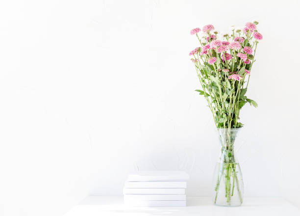 istock White book mockup with chrysanthemum flowers in a vase on a white table 1419229089