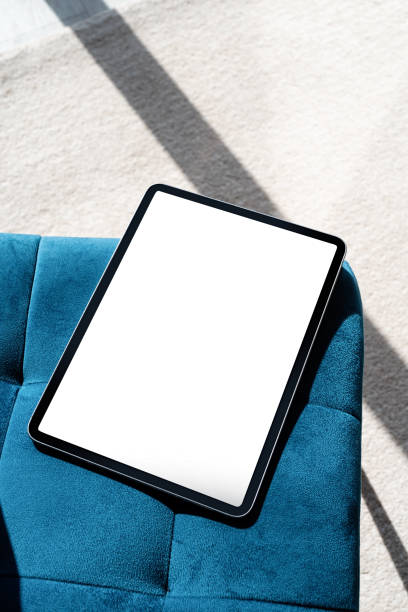 istock Digital tablet computer with isolated screen on blue chair. At home interior. 1419229846
