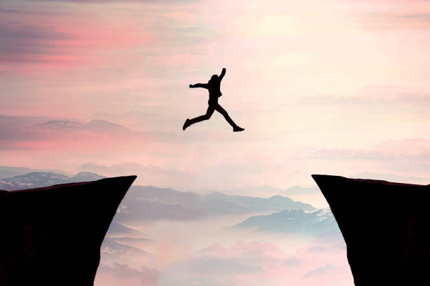Go ahead and continuously improvement concept, silhouette man jump on a cliff from past to future