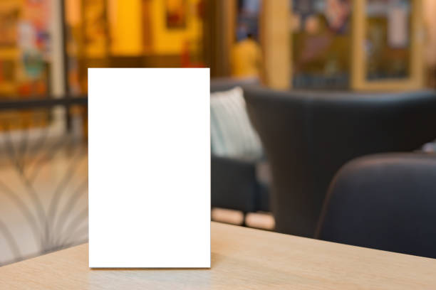 istock Mock up Label the blank menu frame in Bar restaurant ,Stand for booklets with white sheets paper acrylic tent card on wooden table cafeteria blurred background can inserting the text of the customer. 1419232146