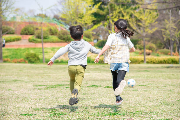 crianças japonesas jogando futebol no parque - family with two children family park child - fotografias e filmes do acervo
