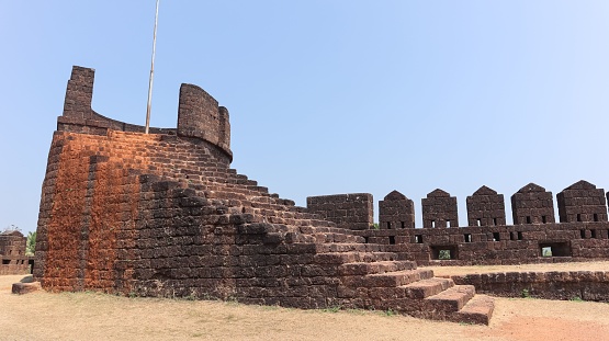 This photograph is taken from the vantage point of Batul Fort in Goa, India, offering a panoramic view that captures the essence of this coastal state. The fort, a historic structure overlooking the Arabian Sea, provides a unique perspective of the juxtaposition between the ancient and the modern, with fishing boats and water sports activities often visible in the distance. The image encapsulates the scenic beauty, rich history, and cultural diversity that make Goa a captivating travel destination.