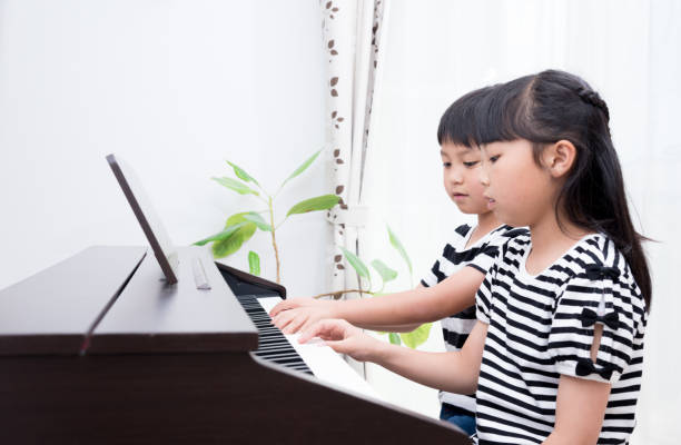 istock Japanese sister and brother practicing piano 1419238896