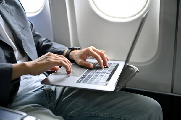 istock A businessman passenger using his laptop during travel on the plane. cropped image 1419242212
