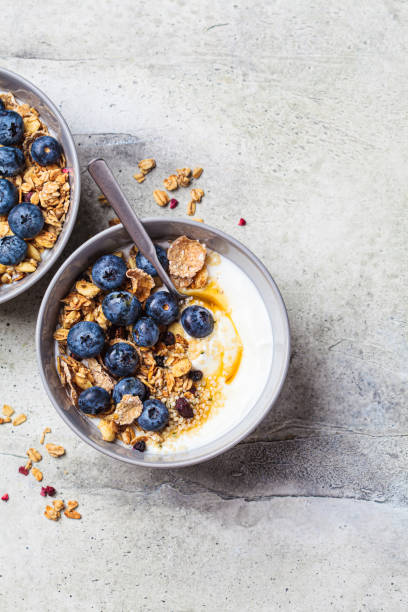 istock Breakfast yogurt bowl with granola, blueberries and maple syrup, gray background. 1419246800