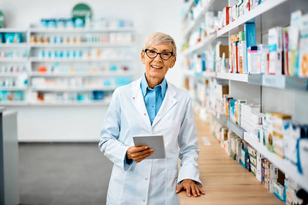istock Happy senior pharmacist using digital tablet in pharmacy and looking at camera. 1419247234
