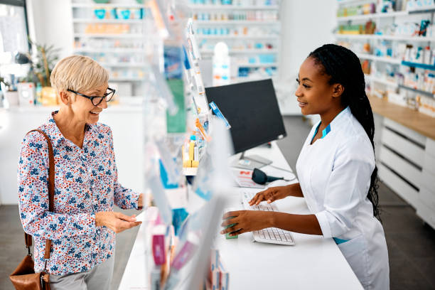 Let me see if we have your prescription medicine! Happy senior woman buying prescription medicine in a pharmacy. pharmacy stock pictures, royalty-free photos & images