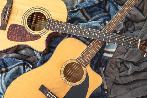 istock Two acoustic guitars on a cozy plaid, top view. 1419248576