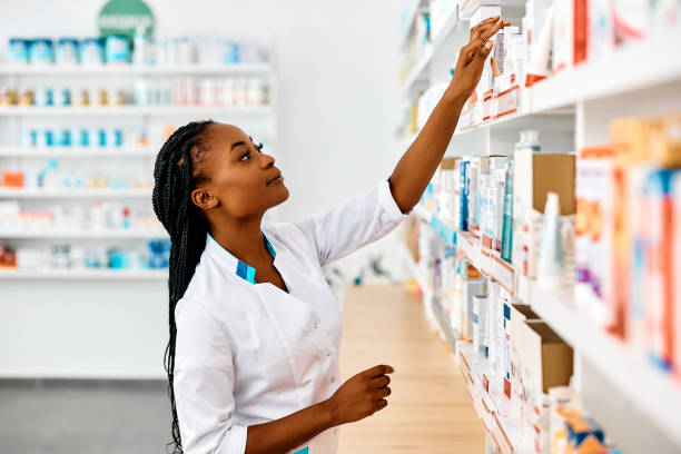 istock Young black pharmacist arranging medicines on shelves while working in drugstore. 1419248698