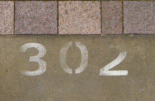Detail of a painted number on a parking lot with paved parking area. abstract background
