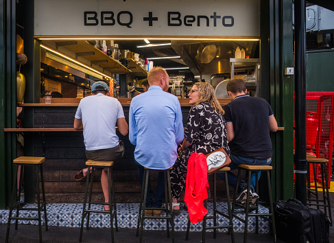 Diners sitting at a street food stall in Borough Market in the heart of London, UK.