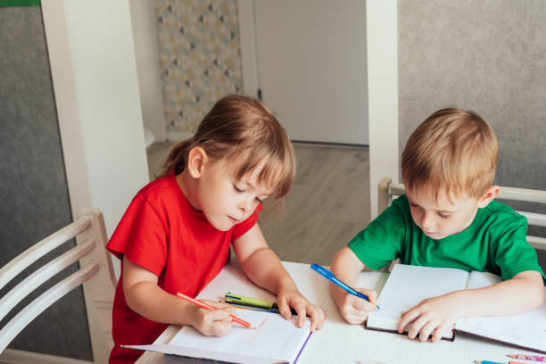 istock Children sit at the table and write in notebooks 1419257359