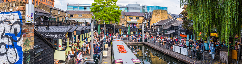 Crowds of tourists and shoppers beside the Regent’s Canal and the busy street food stalls of Camden Market in the heart of London.