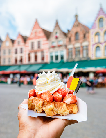 Brugge waffles Belgium, Waffle with cream and strawberry, waffle isolated in hand in Brugge Belgium