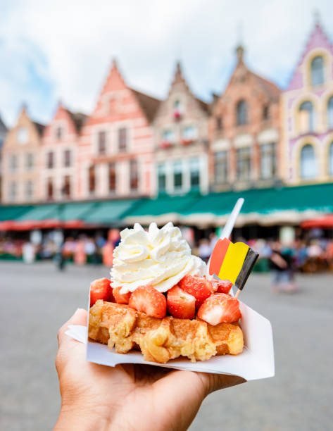 Brugge waffles Belgium, Waffle with cream and strawberry, waffle isolated in hand in Brugge stock photo