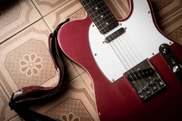 Guitar neck and body, featuring a bright yellow finish and a maple fretboard with visible frets and strings. Focus highlights the black single-coil pickup mounted on a white pickguard