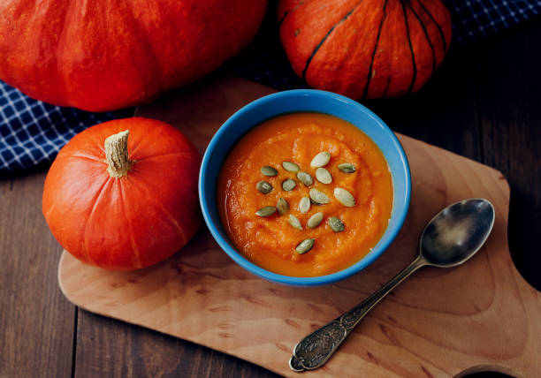 jedzenie i picie, odżywianie dietetyczne, koncepcja opieki zdrowotnej. zupa dyniowa wśród jesiennych liści na drewnianym stole - pumpkin soup soup cup pumpkin zdjęcia i obrazy z banku zdjęć