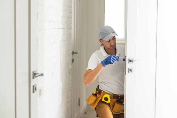 locksmith unscrew the door lock, locksmith repairs the lock in the front plastic door locksmith unscrew the door lock, locksmith repairs the lock in the front plastic door. door repairman men manual worker stock pictures, royalty-free photos & images