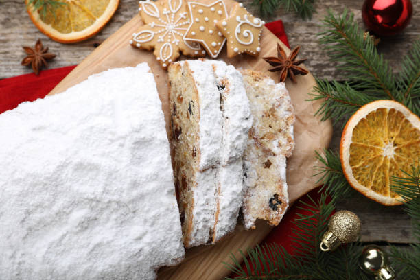 istock Traditional Christmas Stollen with icing sugar on wooden table, flat lay 1419265998