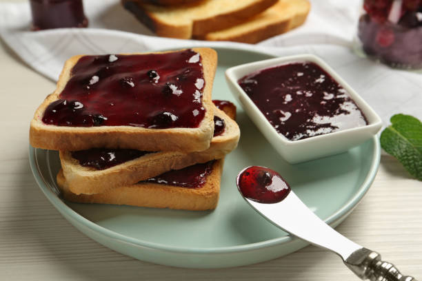 istock Delicious toasts with jam served on white wooden table, closeup 1419267876