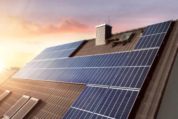 Rooftop of a sustainable German family home with solar panels at sunset.