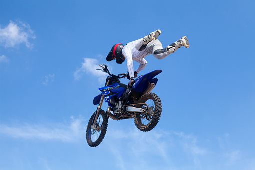 Training, person and motorbike with sky background, fitness and exercise with competition. Biker, practice and athlete with a bike, sports and health with cycling, travel and freedom with energy