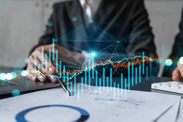 istock Two business people working together on stock market strategy. Try to analyze forex behavior. Financial graph hologram. Double exposure. 1419268681