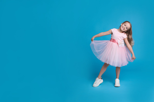 Full-length portrait of a little girls practicing her ballet kicks on a white background; copy space 