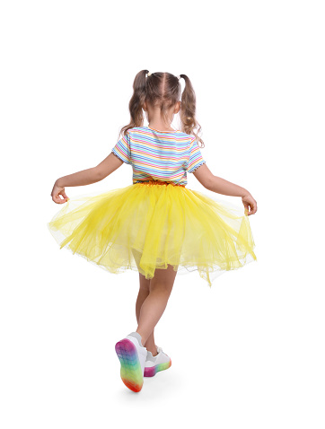 Cute little girl in tutu skirt dancing on white background, back view
