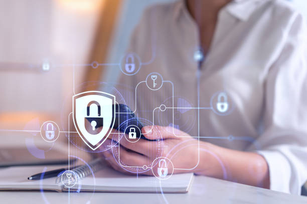 istock A woman programmer is browsing the Internet in smart phone to protect a cyber security from hacker attacks and save clients confidential data. Padlock Hologram icons over the typing hands. Formal wear 1419275925