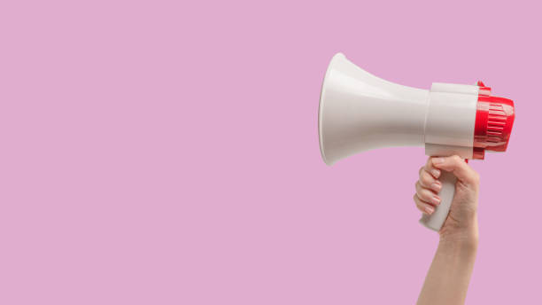 istock Megaphone in woman hands on a pink background. 1419279311