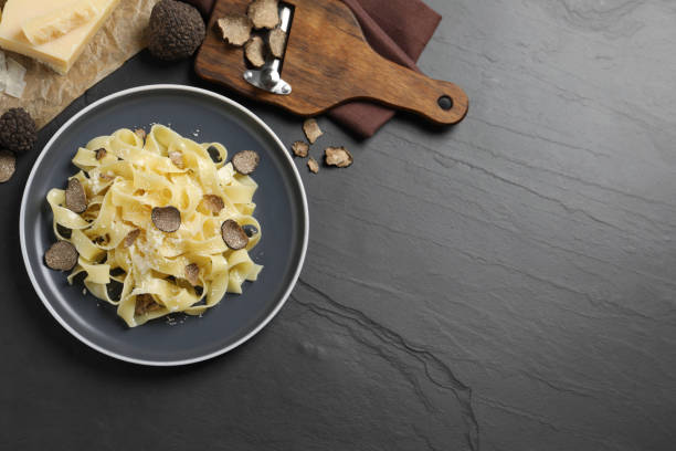 istock Tasty tagliatelle with truffle on black table, flat lay. Space for text 1419281409
