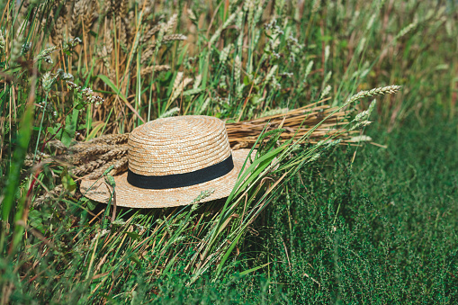 straw hat on the grass with wheat spikelets