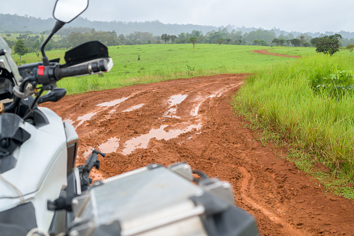 Motorcycle on dirt road in countryside.