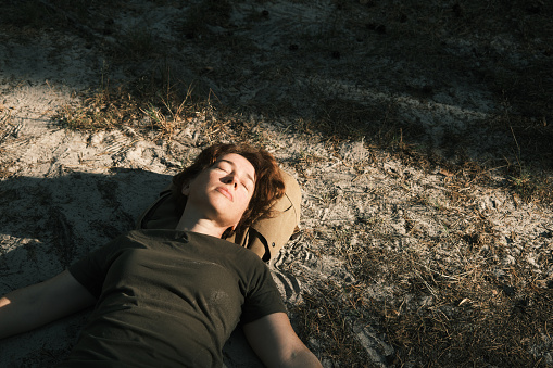 Active mature woman is sleeping in forest