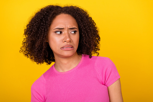 Photo of young lady dissatisfied grimace look empty space isolated on yellow color background.