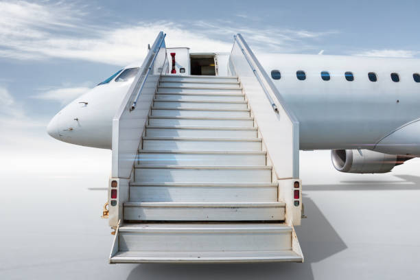 istock White passenger airliner with a stairway isolated on bright background with sky 1419288494
