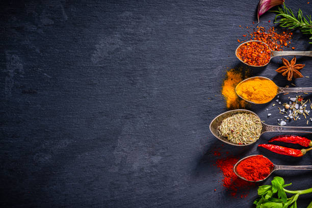 istock Scented herbs and spices on black slate background. Copy space 1419288613