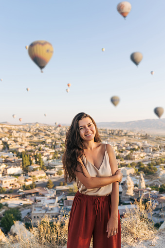 Young woman feels happy and smiling on hot air balloons Cappadocia background