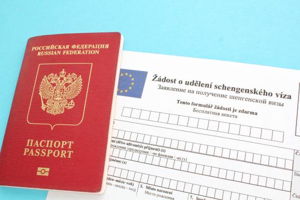 istock Schengen visa application form in Russian and Czech language and passport on blue background 1419290204